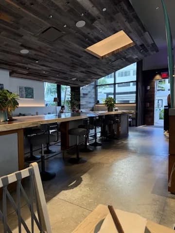木目の天井と大きな窓があるどうとんぼり神座 ワイキキ店の店内