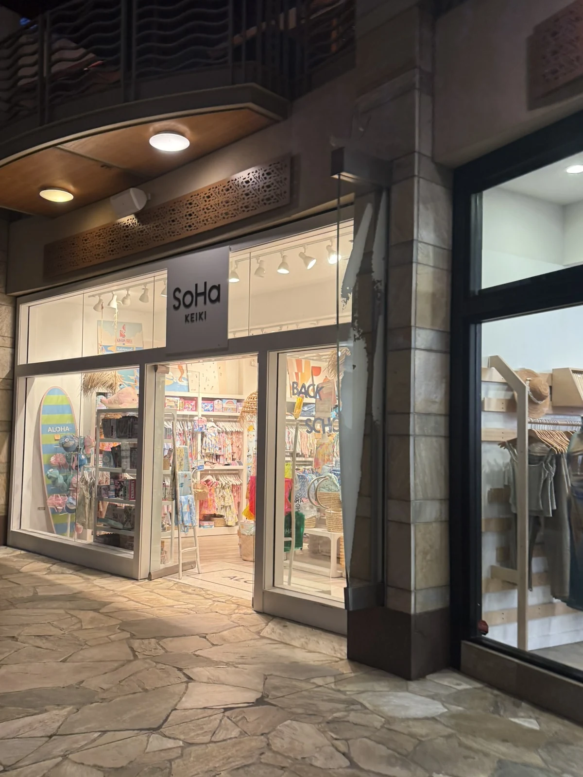 夜のワイキキ・ビーチ・ウォークにあるSoHa Keikiの店舗入口